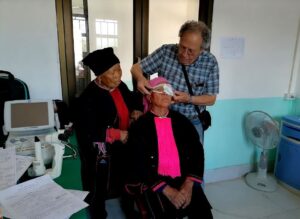 Dr. Luc fitting protective glasses for ethnic minority patient on 1st day post-surgery