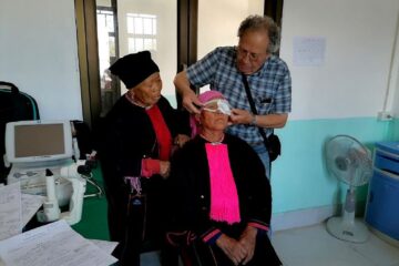 Dr. Luc fitting protective glasses for ethnic minority patient on 1st day post-surgery